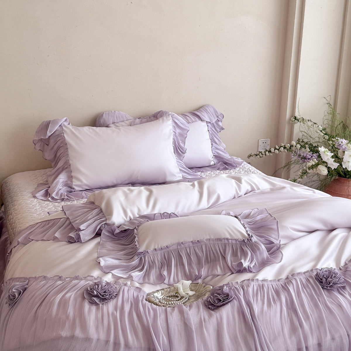 Romantic satin bedding set with layered ruffles and rose appliqués