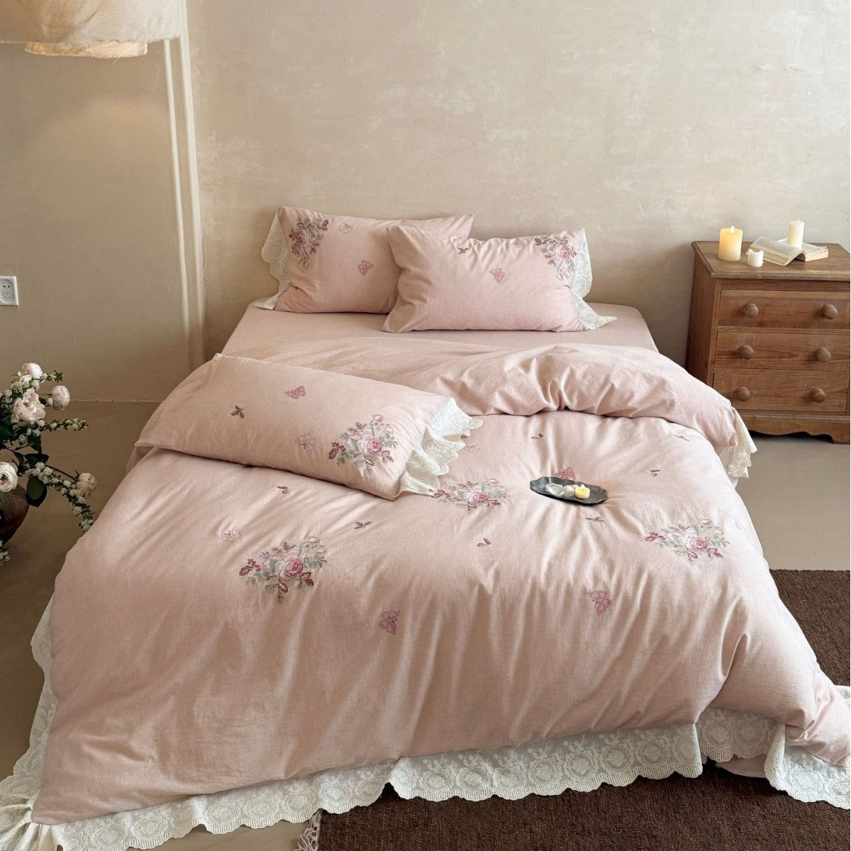 Embroidered cotton-linen bedding set with rose motifs, lace ruffle, and natural texture