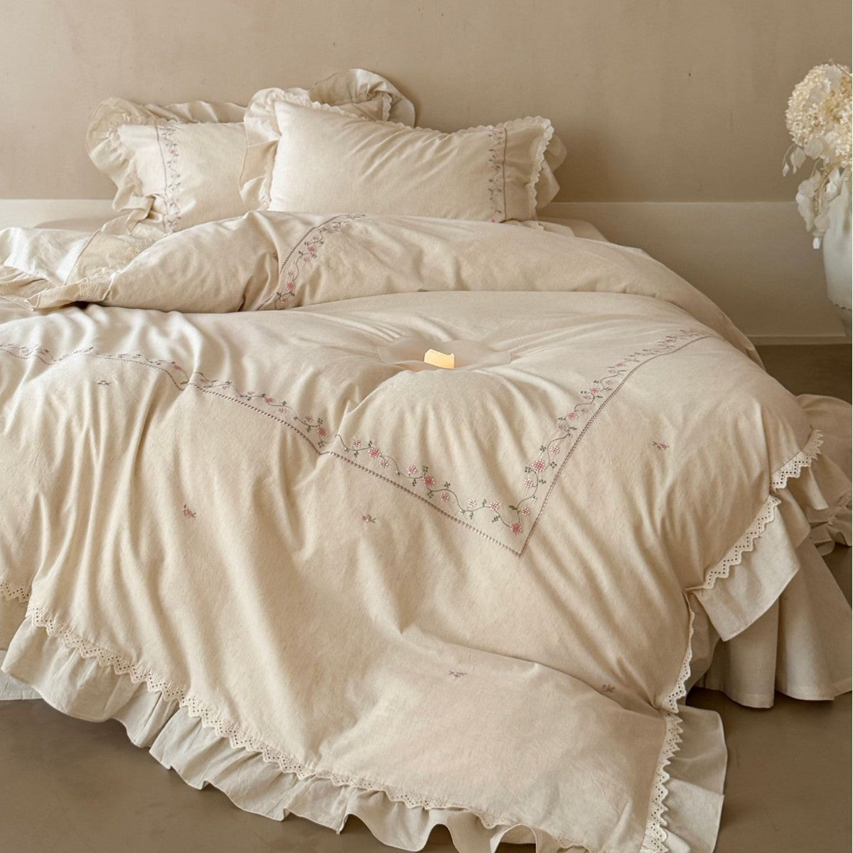Vintage-inspired cotton bedding set with ruffles, delicate floral embroidery, and lace trim