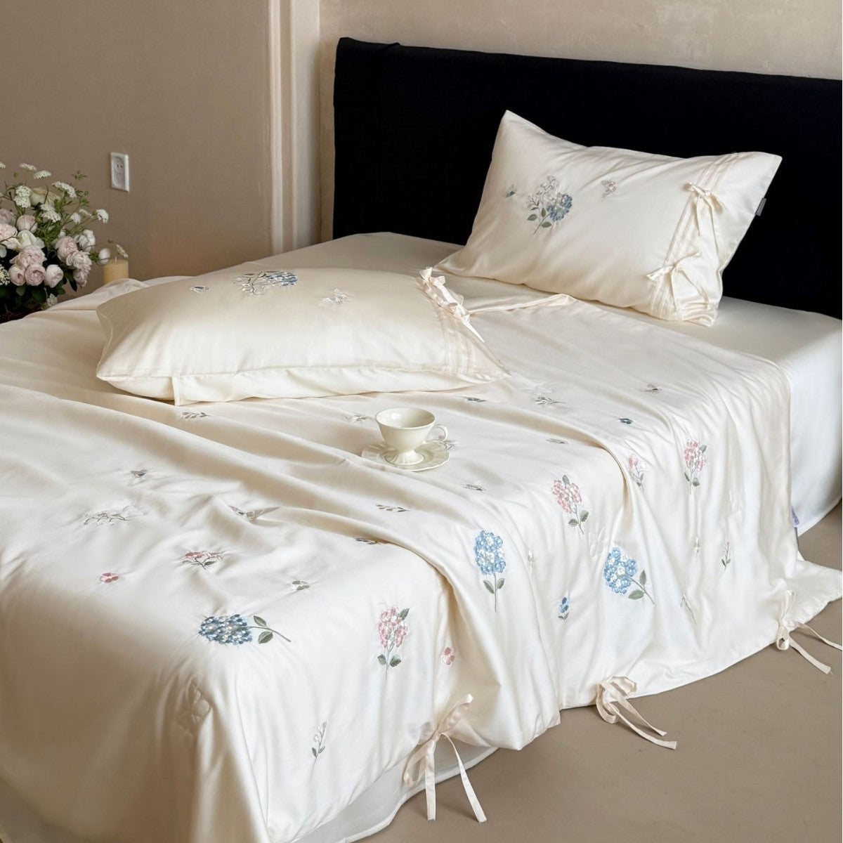 Satin bedding set with floral embroidery, tie ribbons, and silky glossy finish